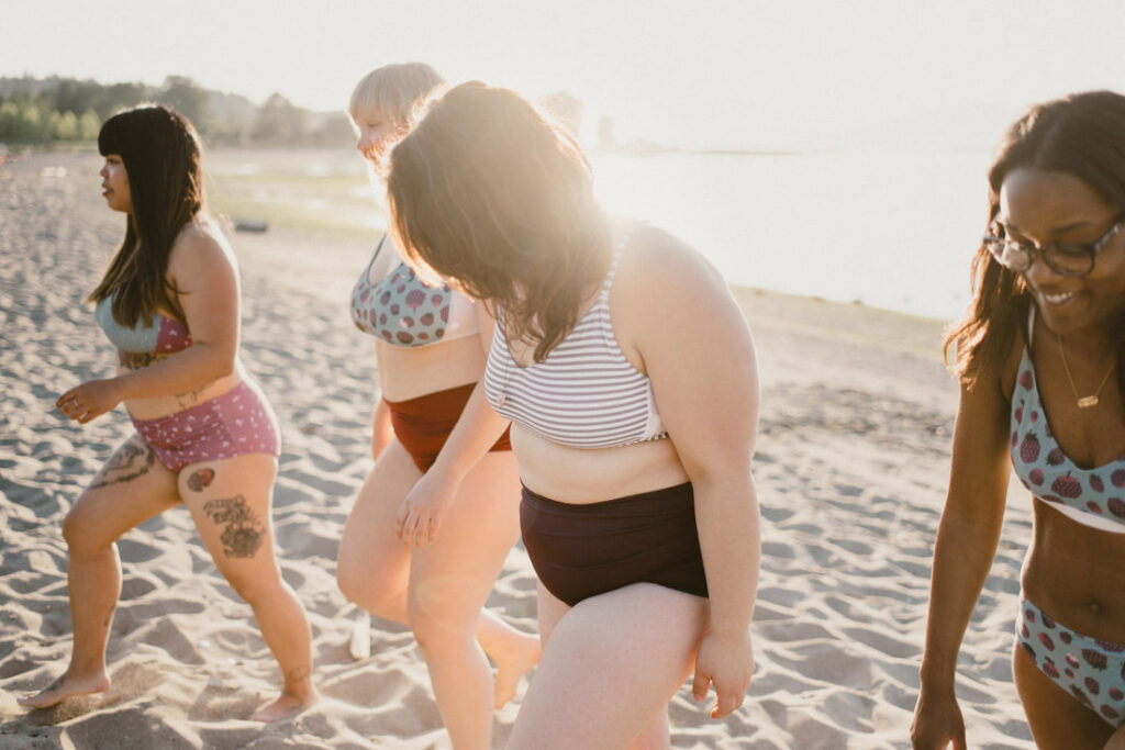 Four women enjoying the sun and sea in their ethical swimwear